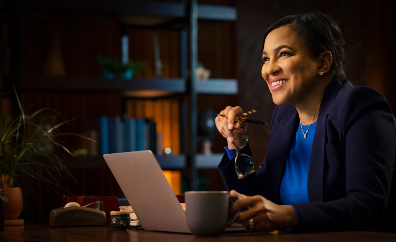 Rosalind Brewer looking up from computer and smiling